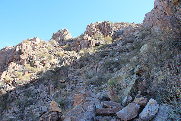 The cairned trail leads to the summit ridge just left of center above