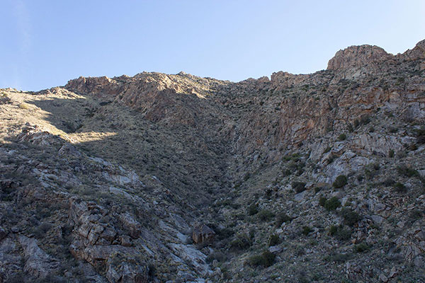 The trail traverses from right to left towards the ridge high above