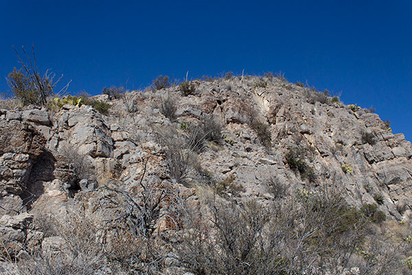 Short but unstable cliffs guard the summit
