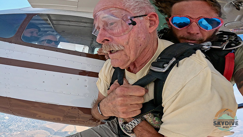 I look 9000 feet below my feet and prepare to jump. Linda watches from the plane.